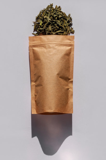 棕色的牛皮纸纸袋与茶叶顶视图与白色背景上的粗糙阴影。咖啡包装平铺。图片下载