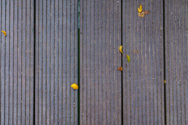 高角度的木板路与稀疏的落叶。图片下载