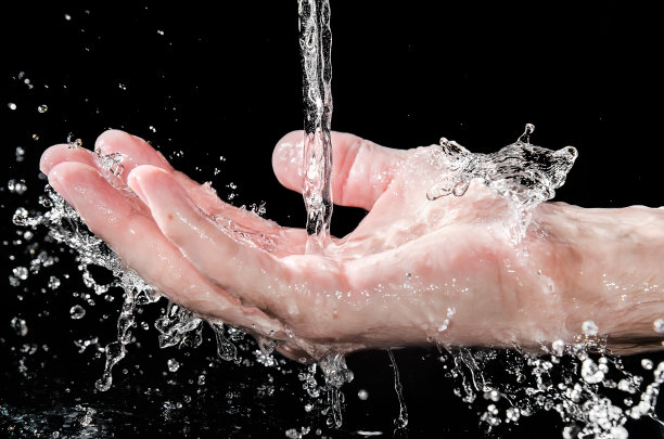 男子手把水花溅在黑色背景上，选中焦点图片下载