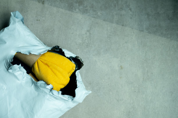 塑料运输袋的开放与黄色内裤在水泥地板上。包装后图片下载