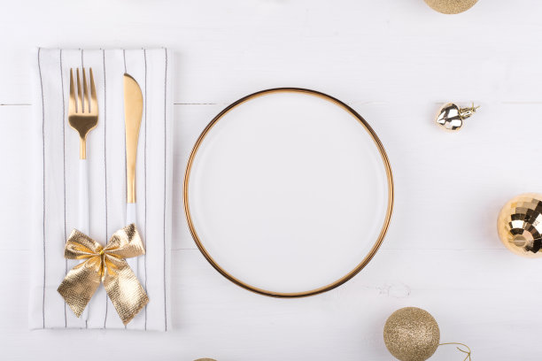 金色边框的白色盘子，周围有圣诞装饰，新年菜单，节日餐桌设置图片下载