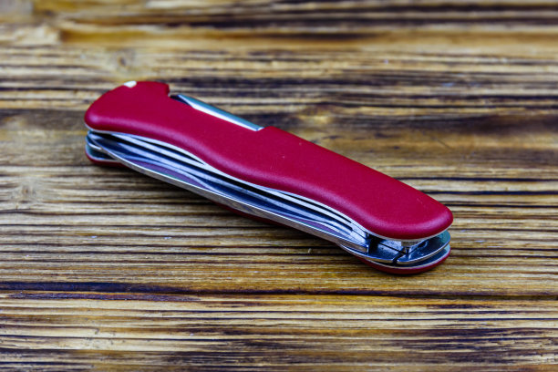 折叠的所有用途的红色口袋刀在一个木制的背景图片下载