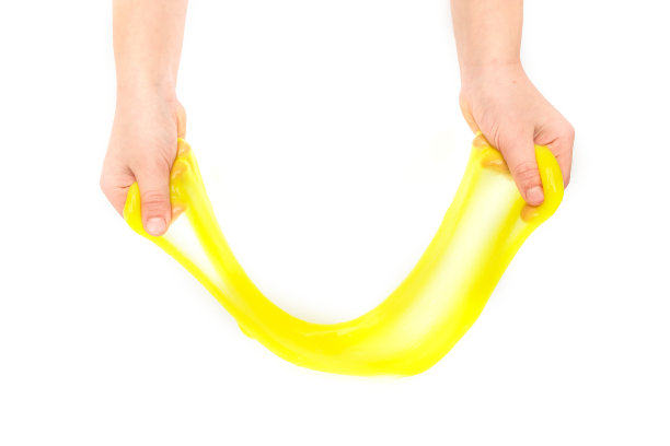 现代玩具叫做黏液。孩子玩透明的黄色黏液。双手拿着一个粘液孤立在一个白色背景。有选择性的重点。图片下载