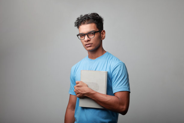 印度裔的年轻人手里拿着一本书图片下载