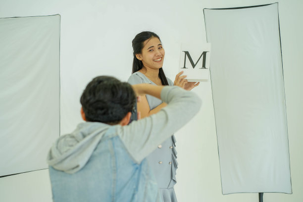 摄影幕后:摄影师用数码相机在创意家居工作室拍摄女模特的照片图片下载