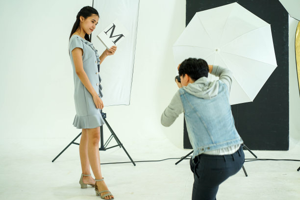 摄影幕后:摄影师用数码相机在创意家居工作室拍摄女模特的照片图片下载