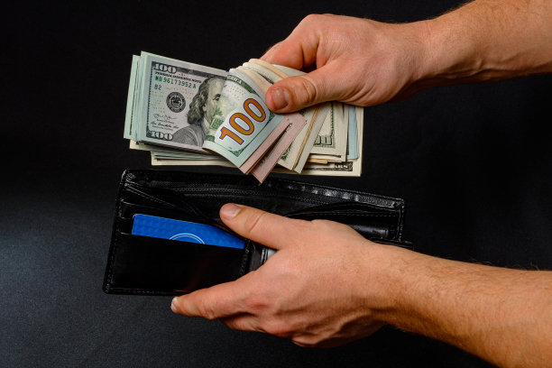 一只手拿着一个黑色皮夹的钱图片下载