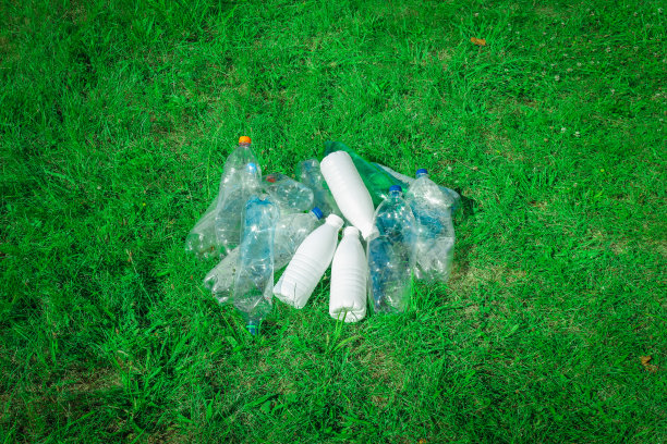 草地上有塑料瓶和瓶盖。图片下载