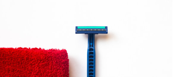 剃刀放在一条红毛巾旁边图片下载