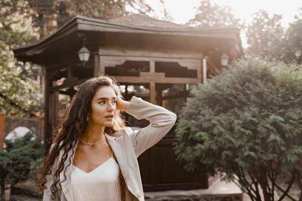 在绿色的公园里的微笑女孩。快乐的年轻女子绕着绿色的花园散步。年轻女商人的生活方式。图片下载