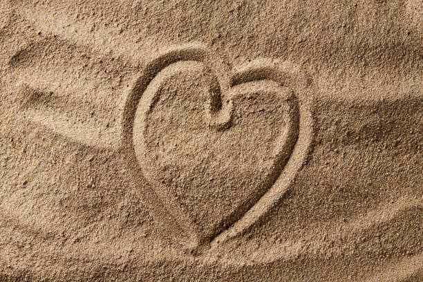 爱情和浪漫的概念。在沙滩上画心形符号。心理健康的概念。黑暗的喜怒无常图片下载