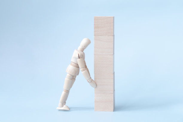一个男人或商人的形象拉着木块，孤立在浅蓝色的背景上。人寿保险，商业战略，风险管理图片下载