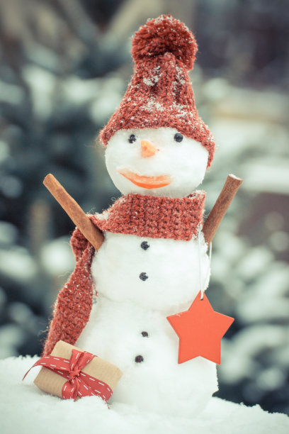 古董照片，雪人与礼物的圣诞或情人节在背景的针叶树覆盖的雪图片下载