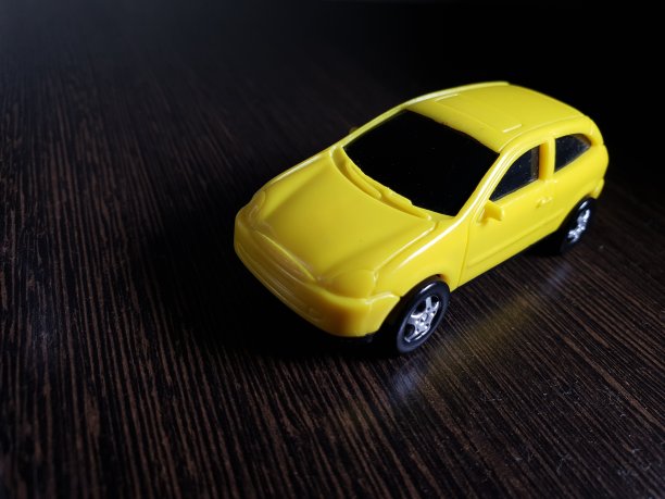 黄色的玩具车以黑色为背景，一辆概念概念的出租车在检疫期间运送货物图片下载