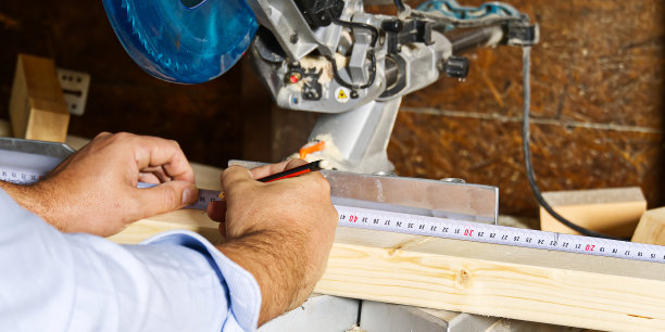 木匠用圆锯切割木条，他锯木条，建筑和家庭装修。木匠的工作概念图片下载
