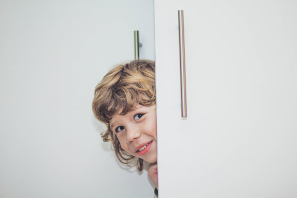 小男孩藏在衣柜里的照片图片下载