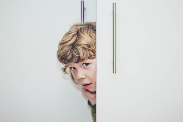 小男孩藏在衣柜里的照片图片下载