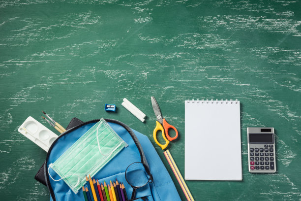 书包放在绿色的黑板上，用口罩保护图片下载