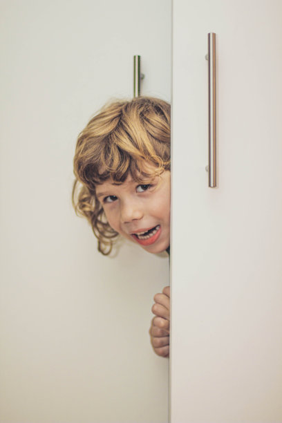 小男孩藏在衣柜里的照片图片下载