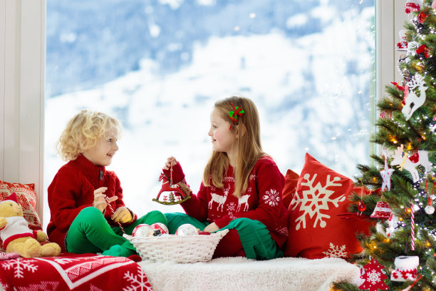 孩子们装饰圣诞树。孩子在圣诞前夜。图片下载