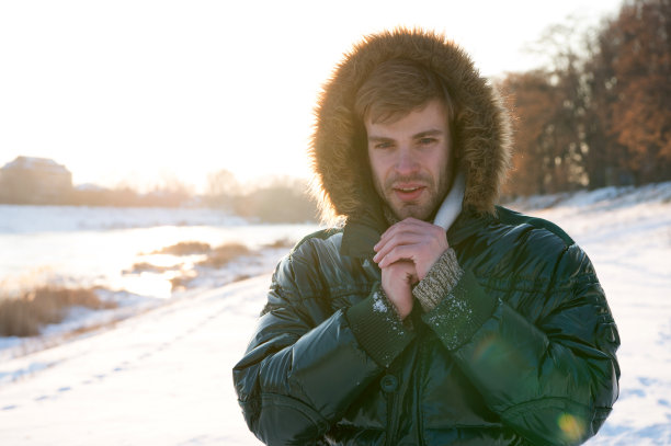人在冬天旅行，自然。寒冷季节穿暖和的衣服。性感的男人在冬天的衣服。冬天的时尚。绿色的温暖的外套。快乐的寒假。流感和感冒。冷冻和神秘图片下载