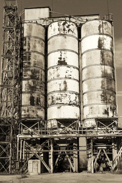 旧的，废弃的混凝土工厂有生锈的铁罐和金属结构。危机爆发，经济下滑，生产能力停止导致崩溃。全球灾难。老照片的效果。图片下载