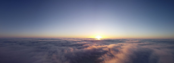 浓雾和晴朗的天空，橙色的太阳照亮了云彩。秋晨雾的全景拍摄图片下载