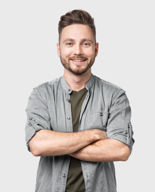 英俊的微笑的年轻人的肖像与交叉的胳膊图片下载