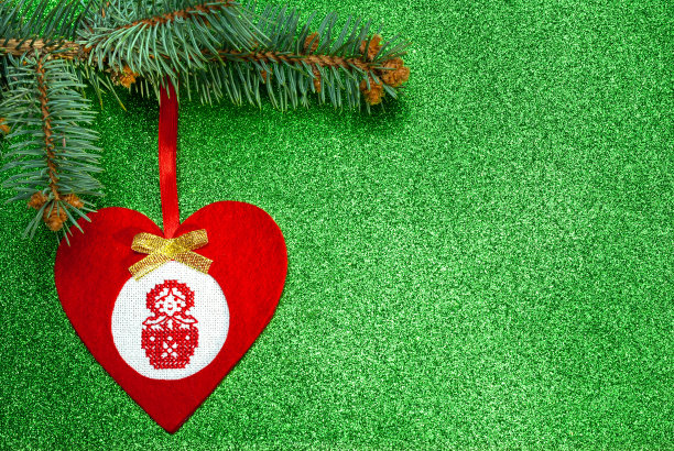 手工制作的红色圣诞树玩具，以心的形式与十字绣俄罗斯套娃图片下载