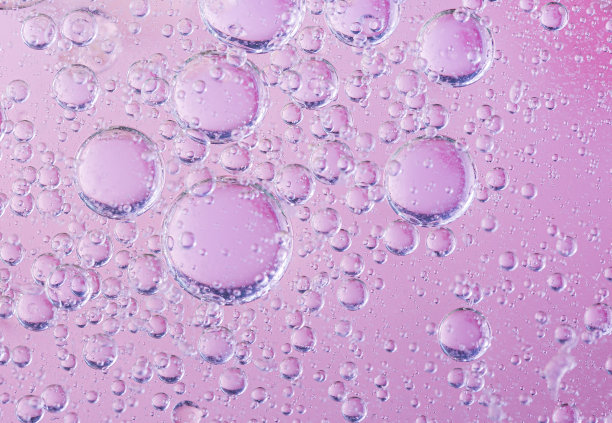 油与泡沫在珊瑚的背景。粉色抽象空间背景。软选择聚焦。油滴在水面的宏观。副本的空间。水中的气泡图片下载