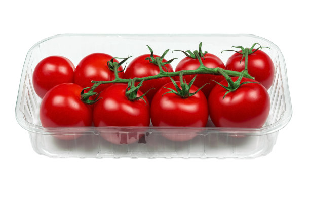 白色背景的盒子里装着新鲜的樱桃番茄。塑料容器里的樱桃番茄图片下载