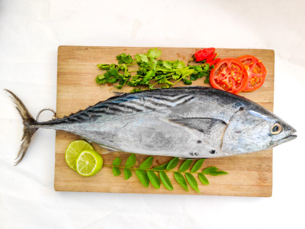 金枪鱼/小金枪鱼，用香草和蔬菜装饰在木垫上。图片下载