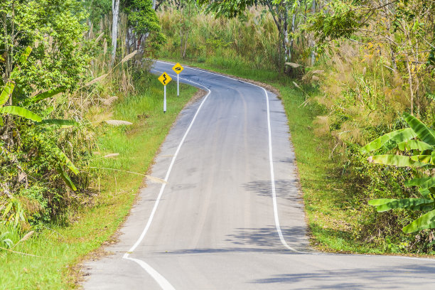 附有警告交通标志的乡村道路。图片下载