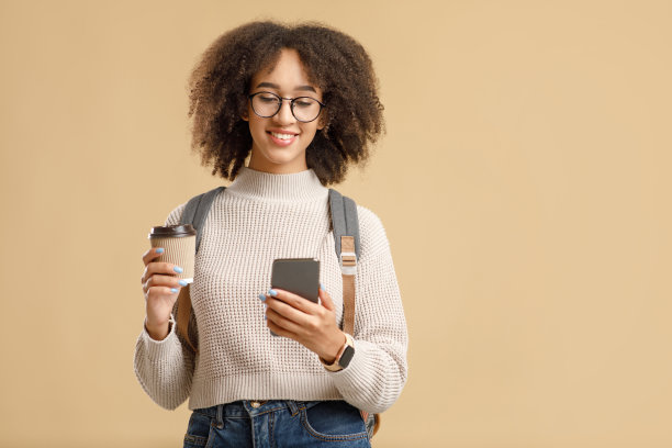 用于远程通信的现代设备。笑容可掬的非洲裔美国妇女，戴着眼镜，背着背包图片下载