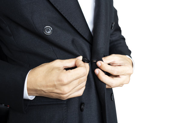 选择性聚焦的那个人是穿着黑色西装的。男人的手系着白色背景的黑色西装。图片下载