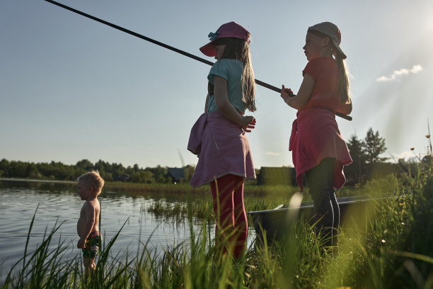 孩子们在一个大湖的岸边钓鱼。图片下载