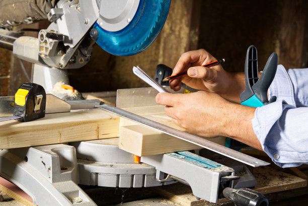 木匠用圆锯切割木条，他锯木条，建筑和家庭装修。木匠的工作概念图片下载
