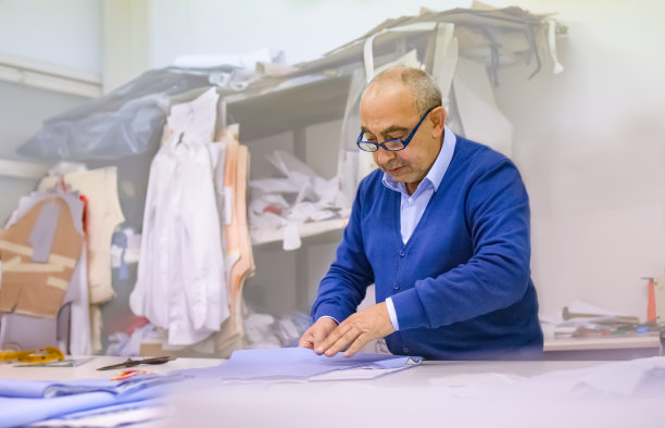 老裁缝在他的工作室里准备纸模型。手工劳动的概念与专业知识和工艺相联系图片下载