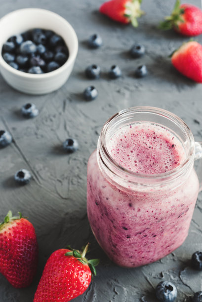 混凝土背景上的自制蓝莓草莓冰沙图片下载