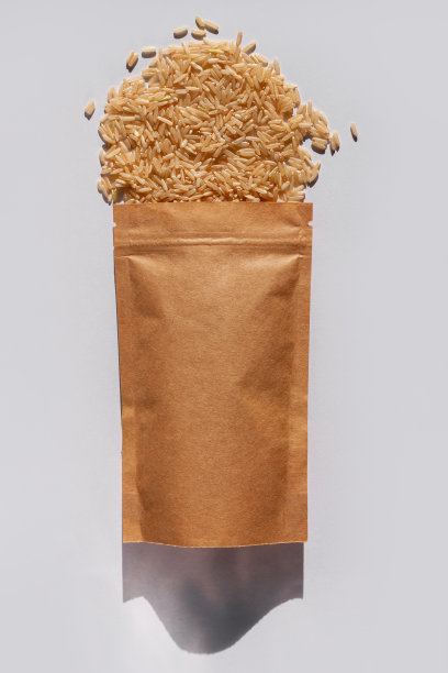 牛皮纸纸袋与全谷物糙米顶视图与粗糙的阴影白色背景。健康饮食谷物食品。图片下载