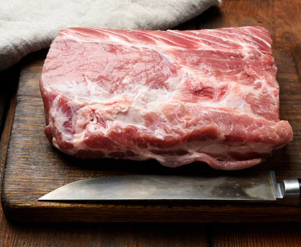 生猪里脊放在木砧板上图片下载