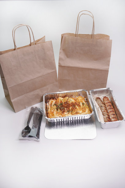 用牛皮纸包装卢拉肉和烤肉串。用锡箔盘递送热食物图片下载