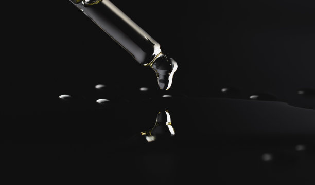 一滴油从玻璃移液管中落下，孤立在黑色背景上。美容、化学、香水。微距照片特写图片下载