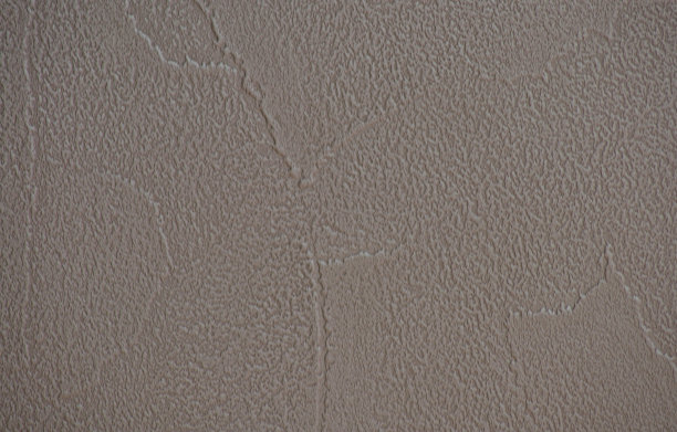 一个碎片的墙壁覆盖着装饰的浅棕色石膏特写。图片下载