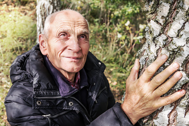 手悲伤的老老人在桦树上低角度拍摄图片下载