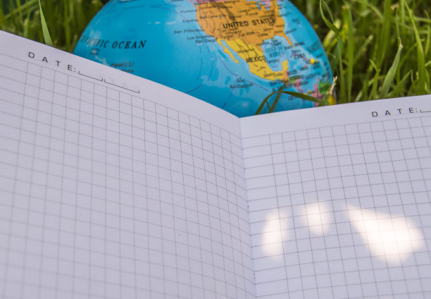 一个打开的空笔记本躺在地球附近的草地上，生态学的概念回到学校，学校放暑假，一个文字的地方图片下载