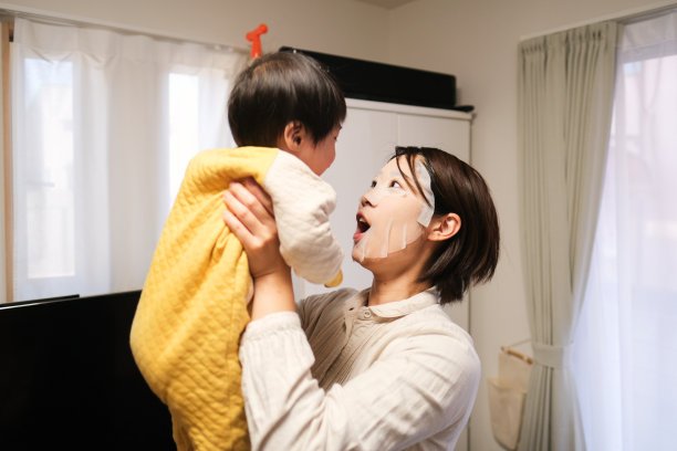 戴着面膜的妈妈在房间里和宝宝玩图片下载