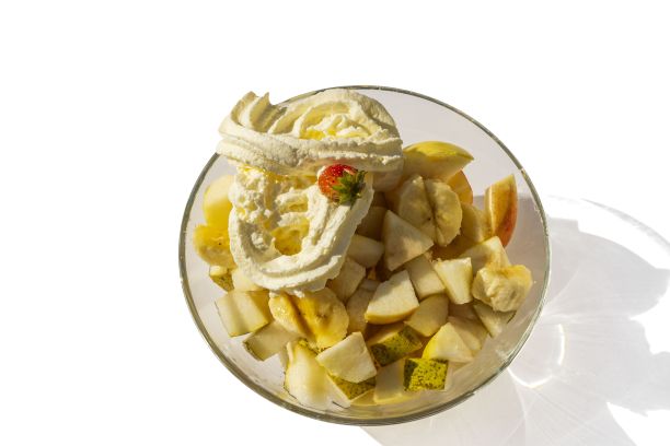 近距离观看水果沙拉与掼奶油在玻璃碗。水果与健康理念。健康饮食。图片下载