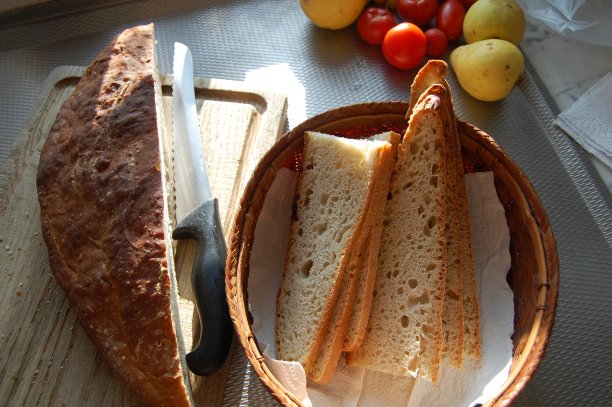 一个巨大的酵母面包，主要由小麦粉制成，被切成薄片，放入面包篮。图片下载
