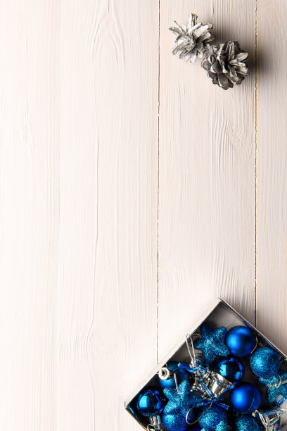 蓝色的圣诞玩具在一个轻木制的背景，与空白的文字在顶部。新年和圣诞节的背景。垂直图图片下载